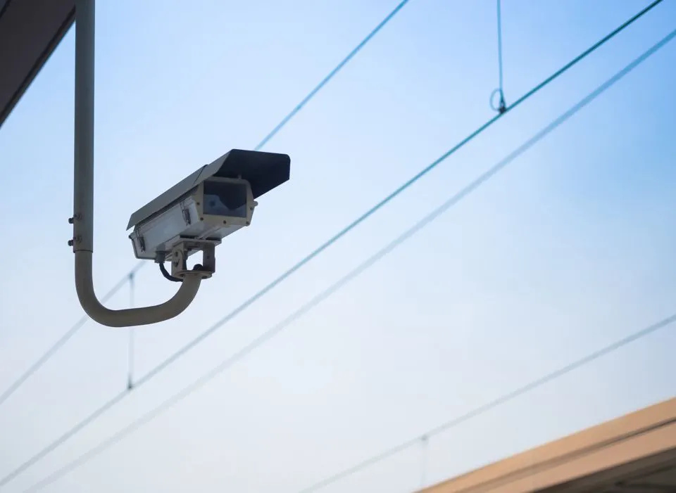 Outdoor security camera mounted on a building monitoring surrounding area for surveillance and safety